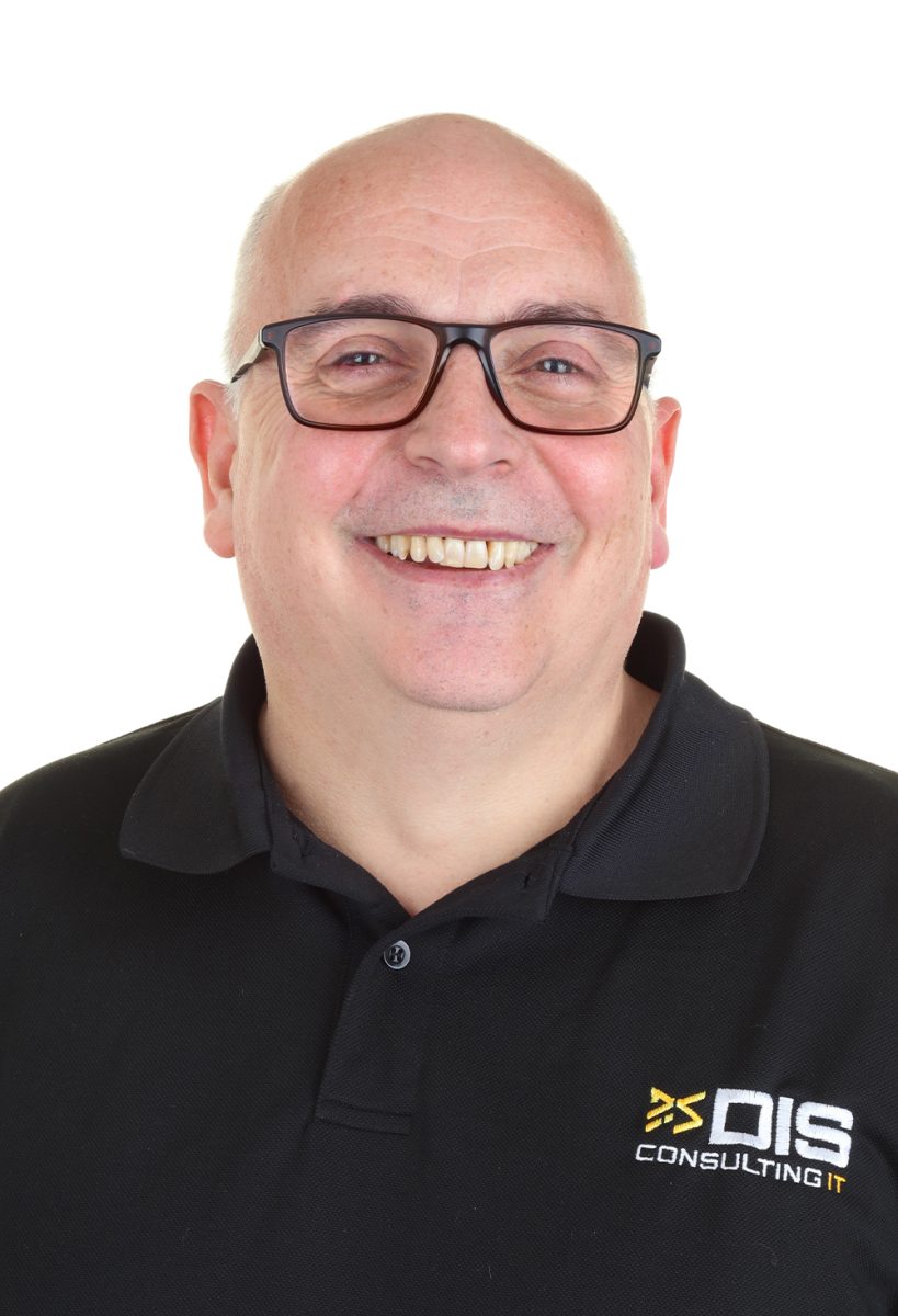 Martin from DIS Consulting IT smiling, wearing glasses and a black branded polo shirt, standing against a plain white background.