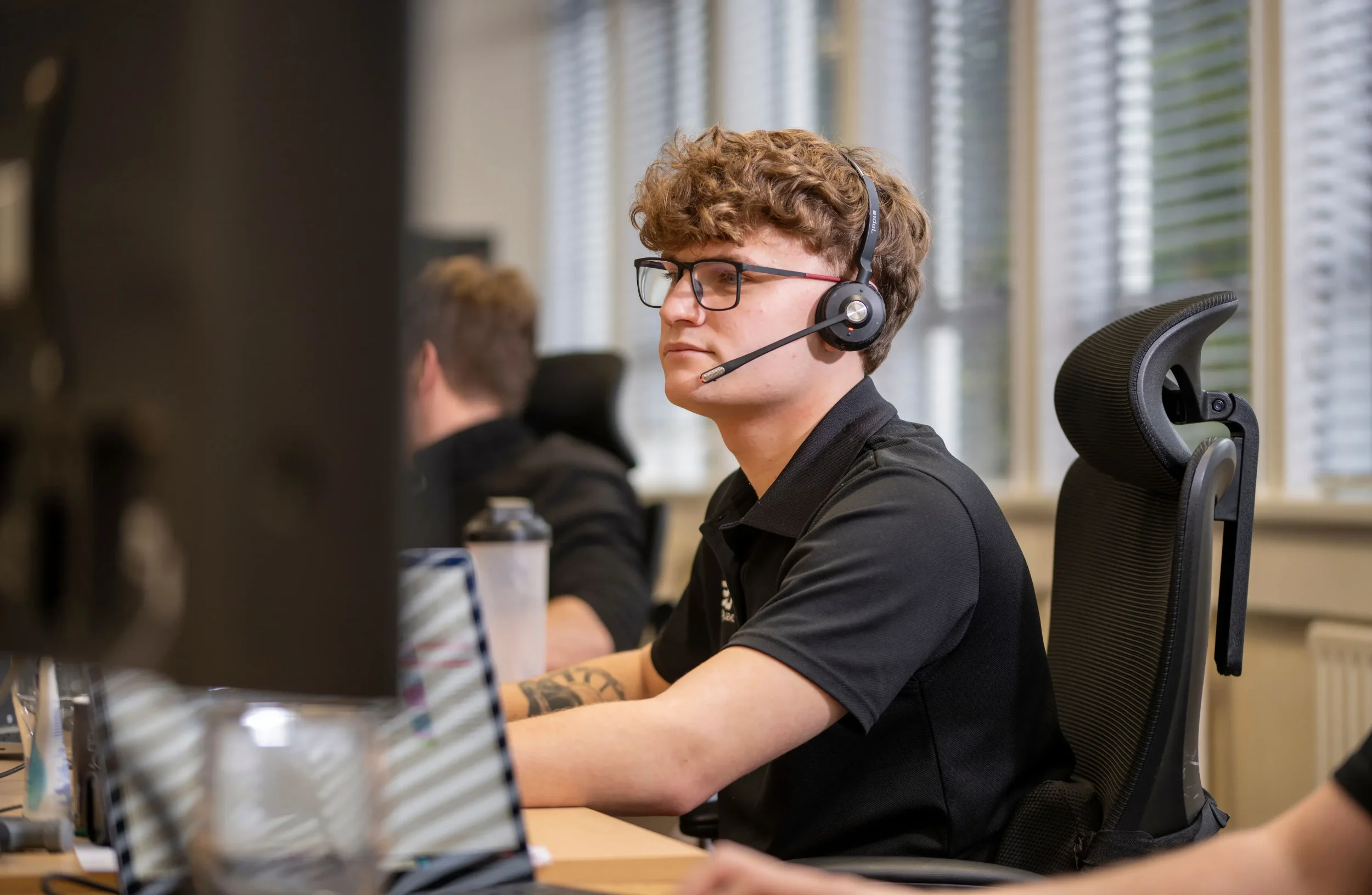 IT support engineer wearing a headset providing remote assistance from the DISConsulting service desk.